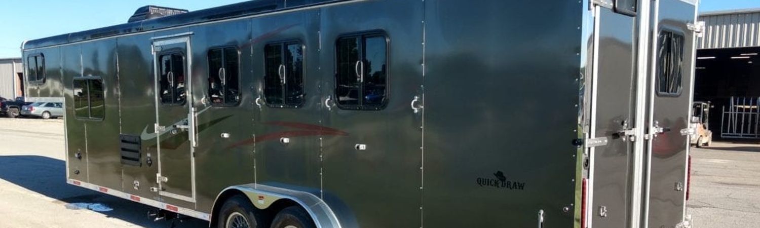 A Bison Trailer Quick Draw sitting in a lot full of cars on a sunny day.